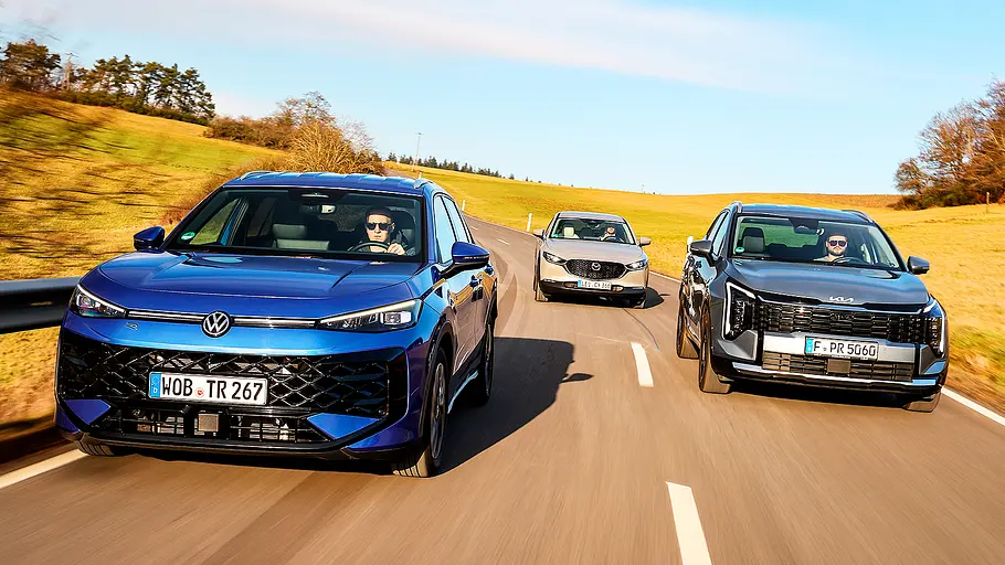 VW T-Roc/Mazda CX-30/Kia Sportage Blick von vorne auf die drei SUV VW T-Roc, Mazda CX-30 und Kia Sportage, die hintereinander her fahren.