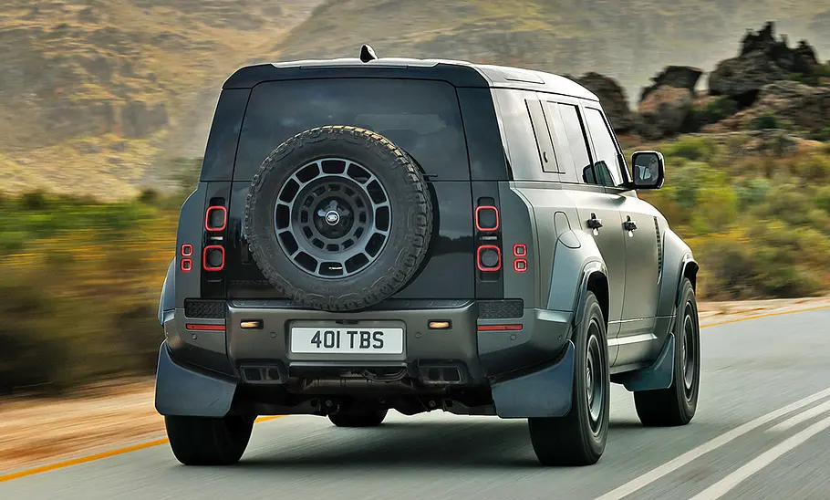 Land Rover Defender Octa (2024) fährt auf einer Landstraße, Ansicht von hinten rechts.