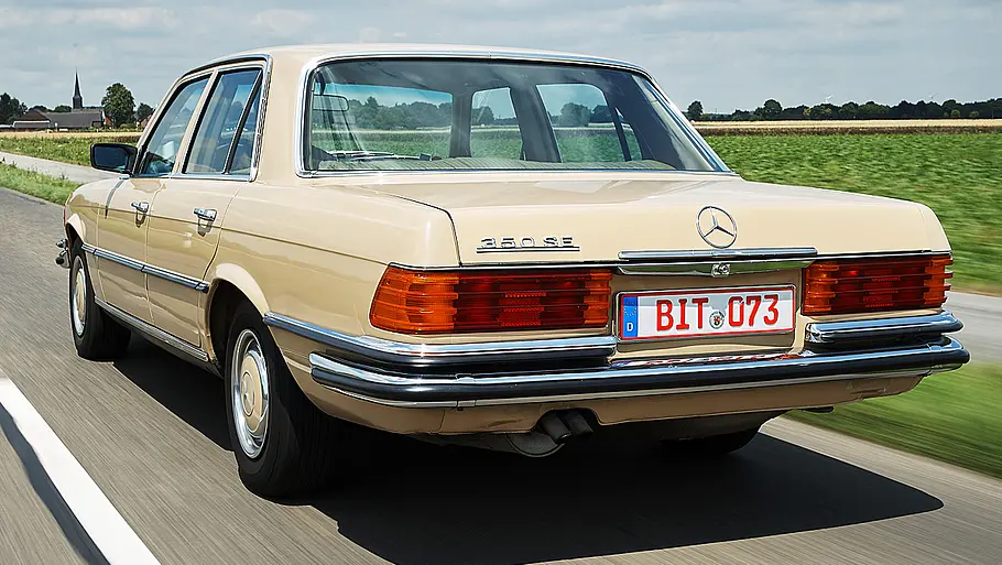Der Mercedes 350 SE fahrend von schräg hinten