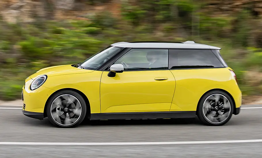 Mini Cooper SE (2024) in gelb, fahrend, von der linken Seite
