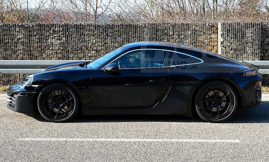 Porsche 718 Cayman Electric (2028) Blick von der Seite auf den fahrenden Erlkönig des Porsche 718 Cayman Electric (2028).