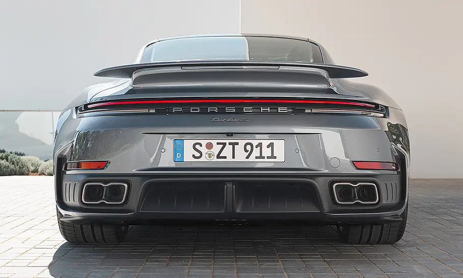 Das Porsche 911 Turbo S Facelift (2025) steht vor einem Haus, von hinten fotografiert.