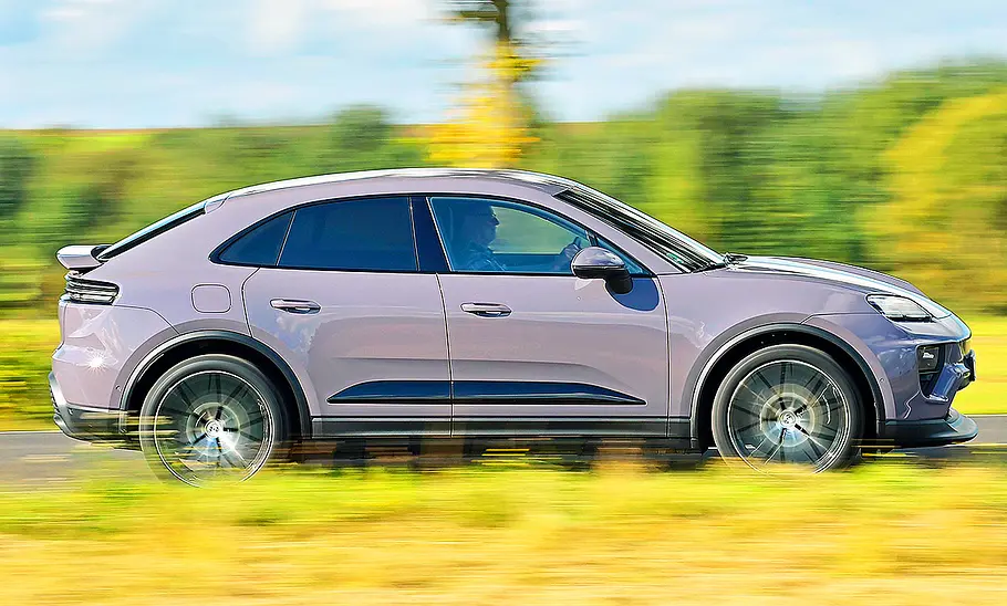 Porsche Macan Electric Blick von der Seite auf den fahrenden Porsche Macan Electric.