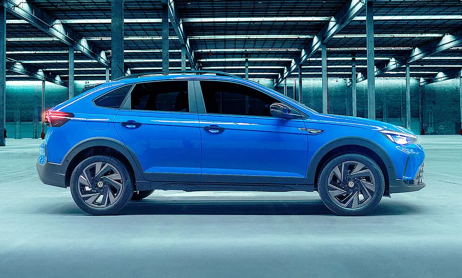 VW Nivus Facelift (2025) VW Nivus Facelift (2025) ist von der rechten Seite in einer leeren Halle fotografiert.