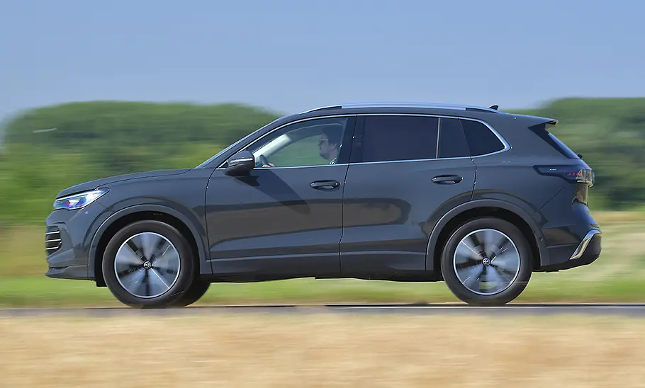 VW Tiguan Der VW Tiguan fährt auf einer Landstraße, Ansicht von der linken Seite.