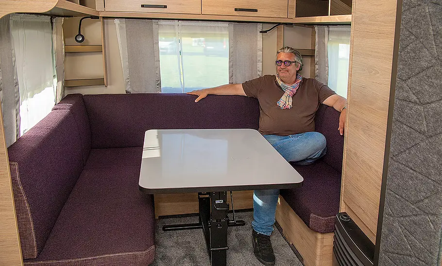 Neuer Weinsberg Caraone 480 EU (2025) Die Innenaufnahme zeigt die Sitzgruppe des Weinsberg Caraone 480 EU (2025). Author Christian Steiger sitzt auf der Sitzbank an der linken Fahrzeugseite.