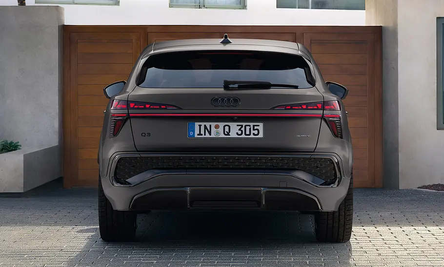 Audi Q3 Sportback 2025 stehend vor Garagentor, fotografiert von hinten.