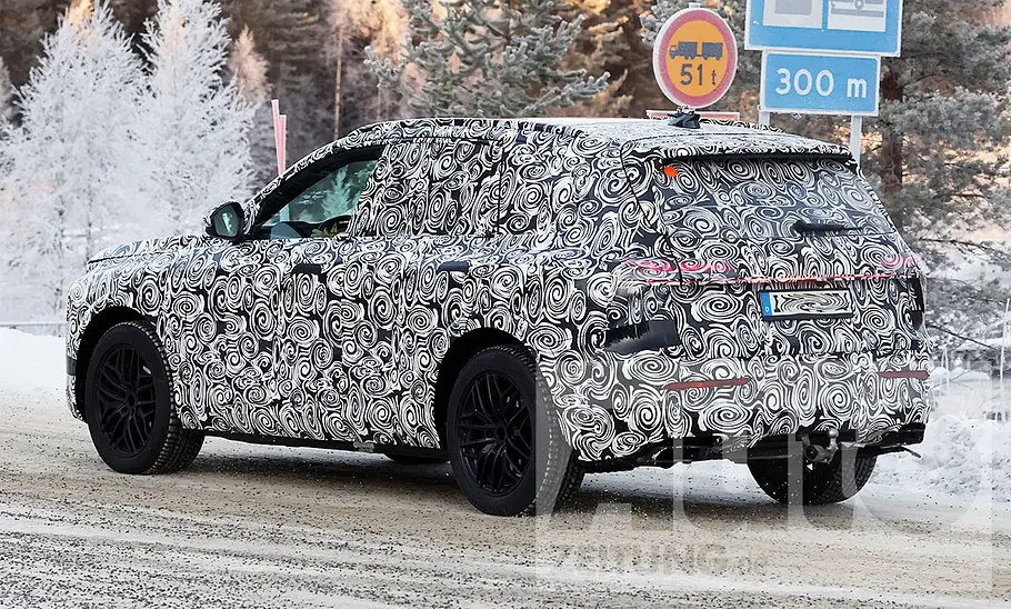 Der Audi Q7 (2025) fährt als Erlkönig durch eine verschneite Gegend; von hinten links fotografiert.