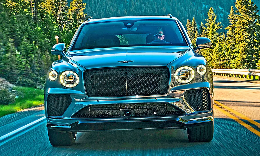 Bentley Bentayga Speed (2025) Bentley Bentayga Speed (2025) fährt auf einer Landstraße, Ansicht von vorne.