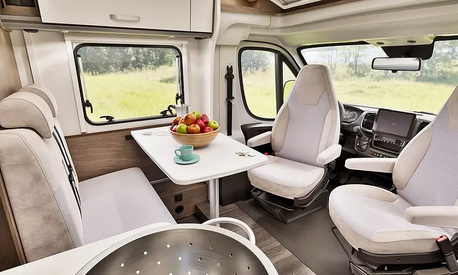 Blick auf die Dinette mit zum Tisch gedrehten Vordersitzen im Carado V339 (2025).
