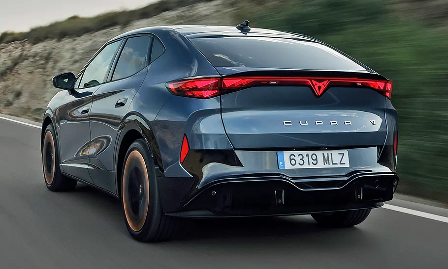 Der Cupra Tavascan (2024) fahrend von schräg hinten fotografiert.