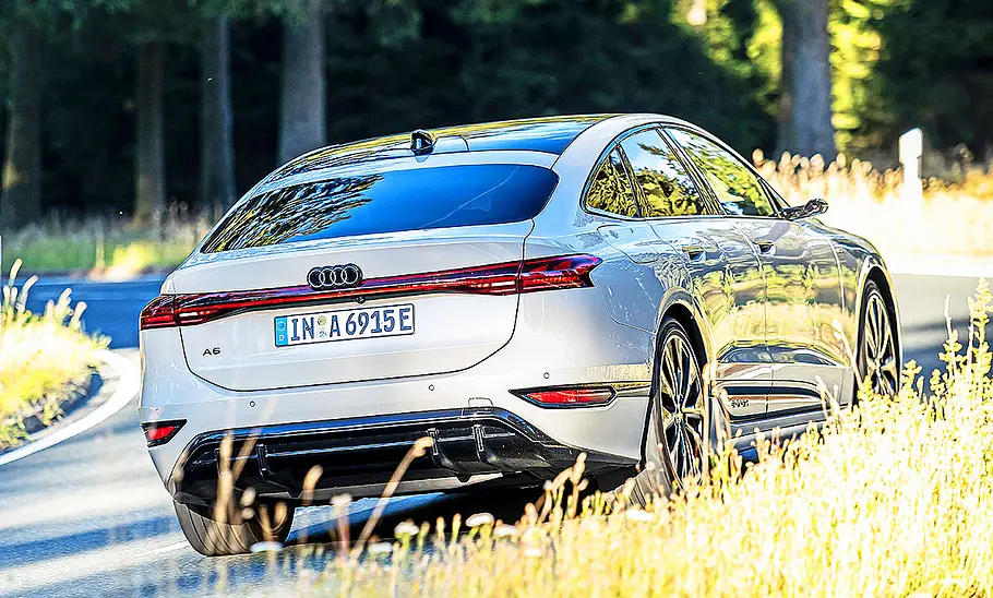 Blick von schräg hinten auf den fahrenden Audi A6 e-tron.