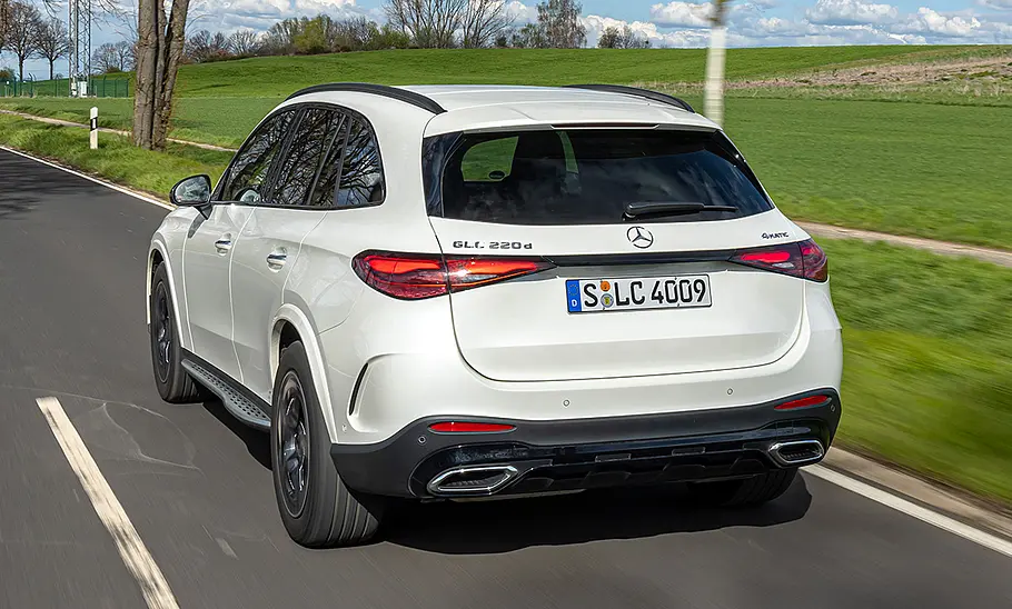 Mercedes GLC Der Mercedes GLC fährt auf einer Landstraße, von hinten fotografiert.