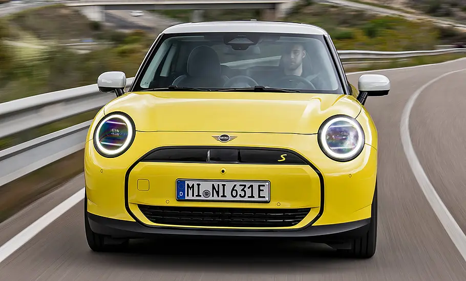 Mini Cooper SE (2024) in gelb, fahrend, frontal von vorne