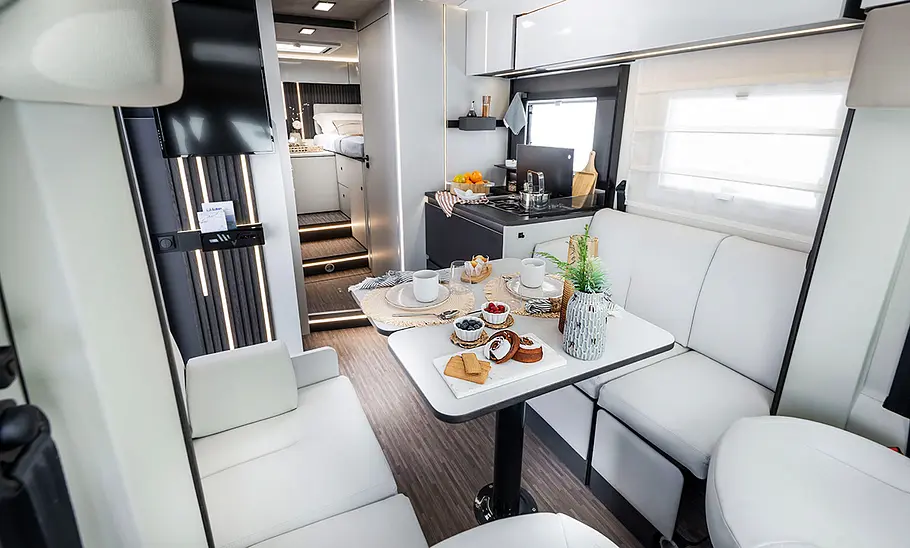 Mobilvetta Kea P86 (2025) Das Bild zeigt die Sitzgruppe des Mobilvetta Kea P86 (2025) vom Beifahrersitz mit Blick schräg durch den Wohnraum in Richtung Heck fotografiert.
