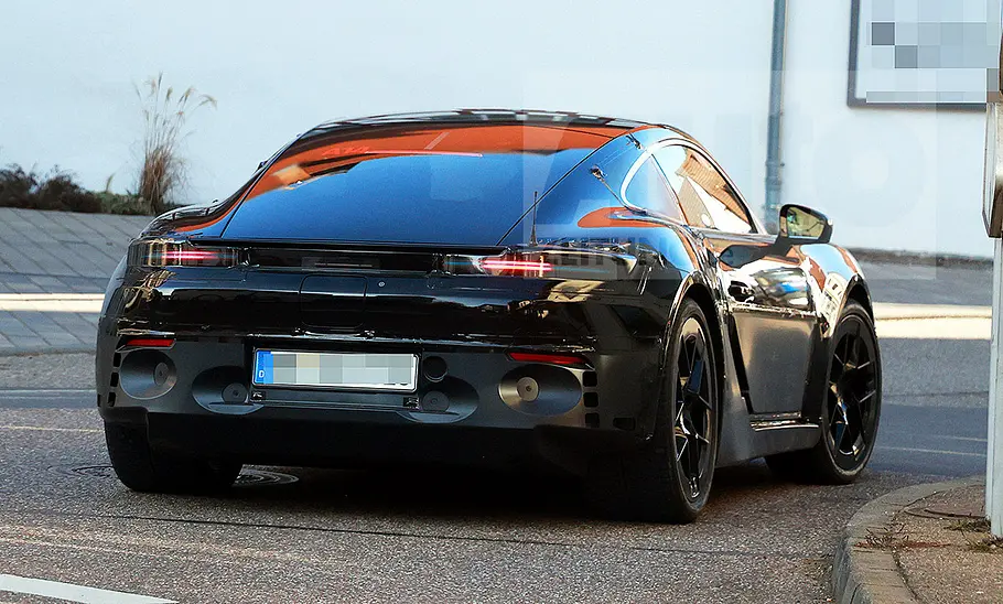 Porsche 718 Cayman Electric (2028) Blick von hinten auf den fahrenden Erlkönig des Porsche 718 Cayman Electric (2028).