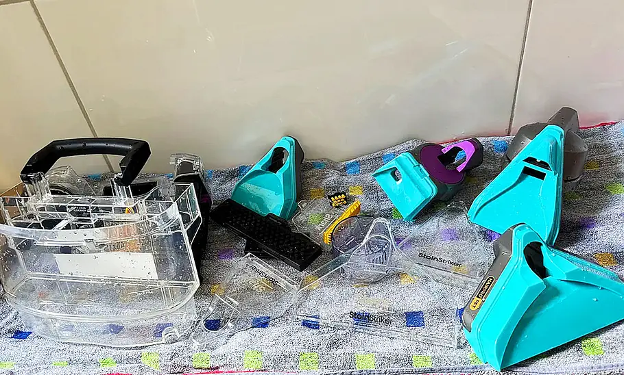 Das Bild zeigt den Shark StainStriker HairPro im Praxistest. Alle Anbauteile sind zur Trocknung nach der Reinigung auf dem Boden ausgebreitet.