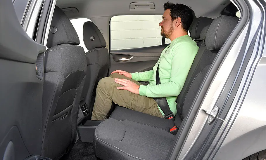 Skoda Fabia (2021) Die Rückbank des Skoda Fabia (2021) mit sitzender Person, durch die geöffnete linke Tür fotografiert