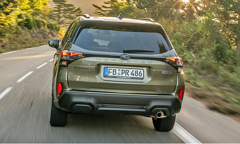 Subaru Forester (2025) Subaru Forester (2025) fährt auf einer Landstraße, Ansicht von hinten.