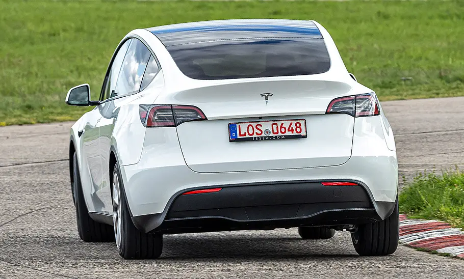Weises Tesla Model Y Maximale Reichweite RWD fahrend, von hinten