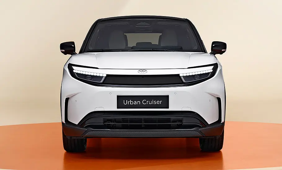 Toyota Urban Cruiser (2025) Toyota Urban Cruiser (2025) im Studio vor beigem Hintergrund, Ansicht von vorne.