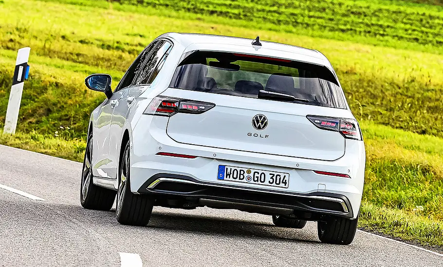 VW Golf Blick von hinten auf den fahrenden VW Golf auf einer Landstraße.