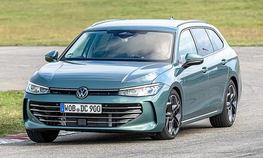 VW Passat Der VW Passat fährt durch eine Rechtskurve. Von vorne fotografiert.