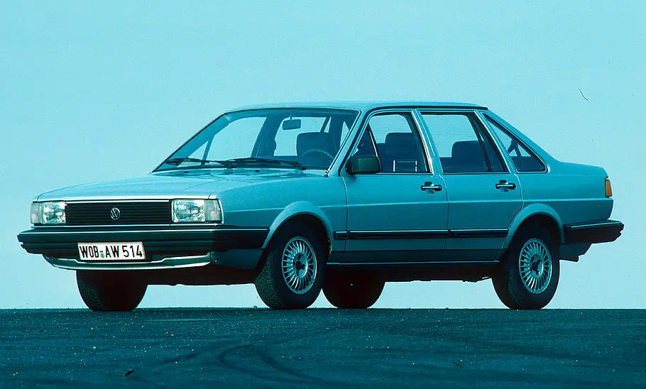 Der VW Santana steht auf einer asphaltierten Fläche, von vorne links fotografiert.