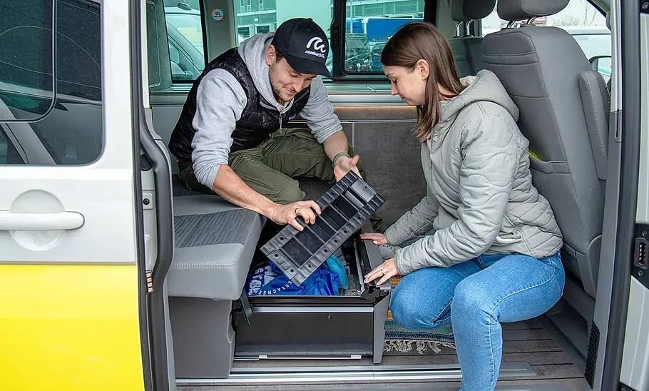 VW T 6.1 California mit geöffneter Schublade unter der Rückbank