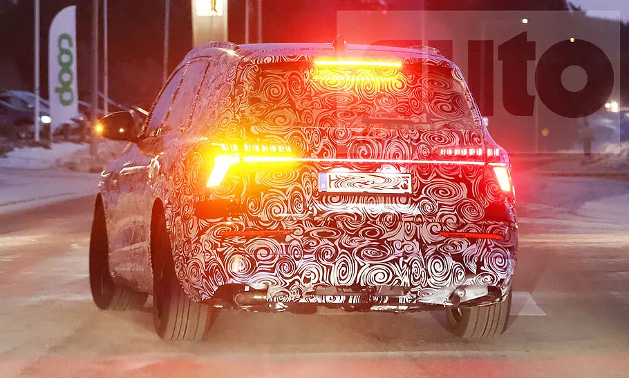 Der Audi Q7 (2025) setzt als Erlkönig blinkend zum Abbiegen an, von hinten fotografiert.