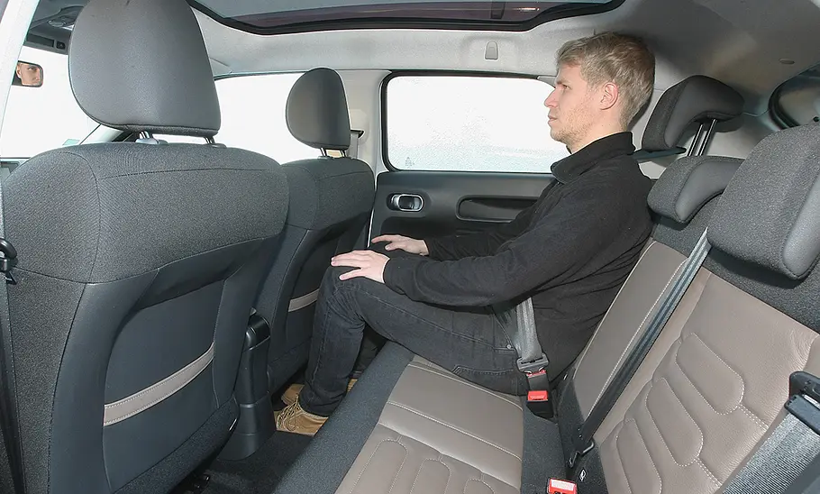 Ein Mann sitzt auf der Rückbank des Citroën C4 Cactus (2014).