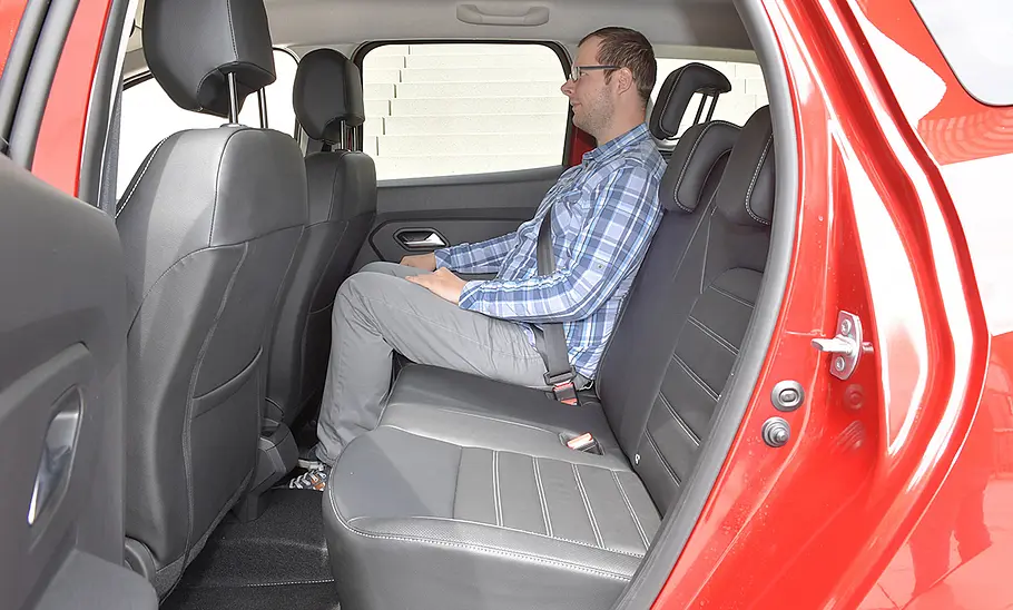 Eine Person sitzt im Fond des Dacia Duster (2018).