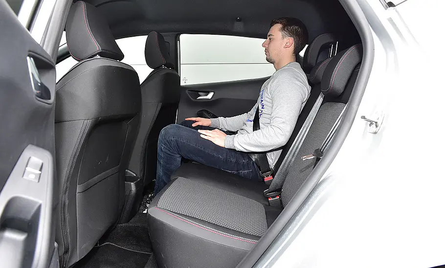 Ein Mann sitzt im Fond des Ford Fiesta (2022).