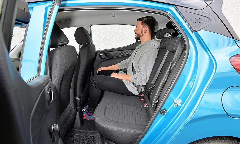 Eine Person sitzt im Fond de Hyundai i10 (2019).