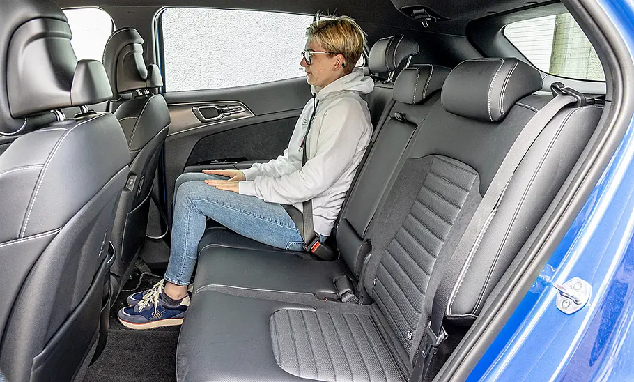 Kia Sportage (2021) Eine Person sitzt im Fond des Kia Sportage (2021).
