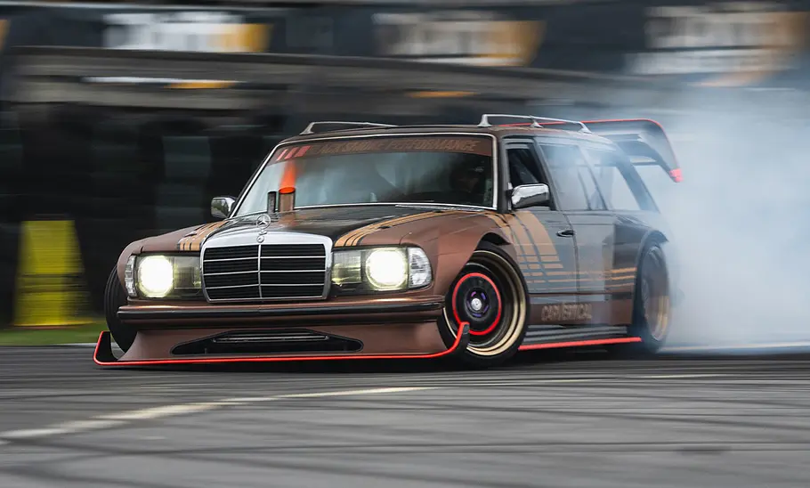 Getunter Mercedes S123 im Drift, fotografiert von schräg vorne.