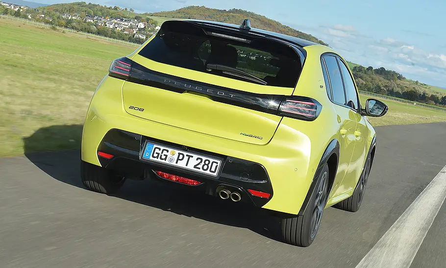 Der Peugeot 208 Hybrid fährt geradeaus, von hinten rechts fotografiert.