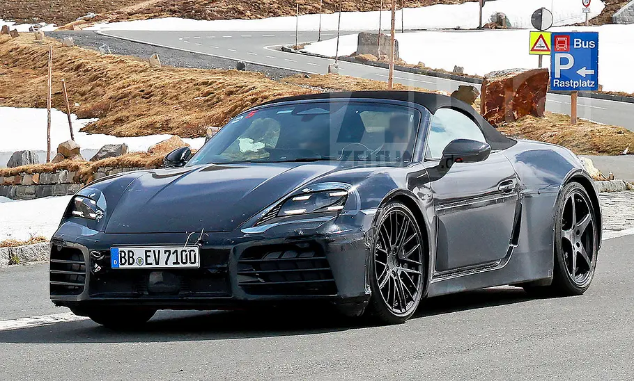 Porsche 718 Boxster Electric (2027) Blick von schräg vorne auf den fahrenden Erlkönig des Porsche 718 Boxster Electric (2027).