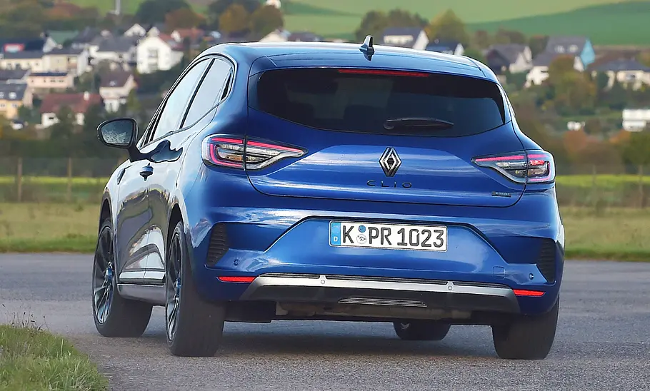Der Renault Clio fährt durch eine Linkskurve, von hinten fotografiert.