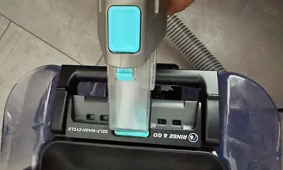 Shark StainStriker HairPro im Praxistest Das Bild zeigt den Shark StainStriker HairPro im Praxistest. Zu sehen ist die Selbstreinigung des Fleckenentferners mit der Fugendüse.