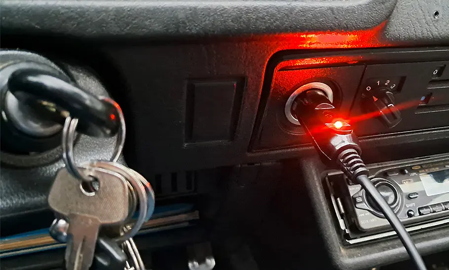 Das Detailfoto zeigt den Stecker der Systafex-Sitzheizung am 12-V-Zigarettenanzünder eines VW Polo.