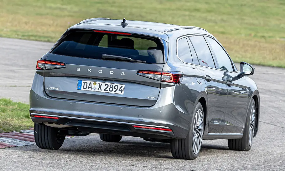 Skoda Superb Combi Der Skoda Superb Combi fährt durch eine Linkskurve, von hinten fotografiert.