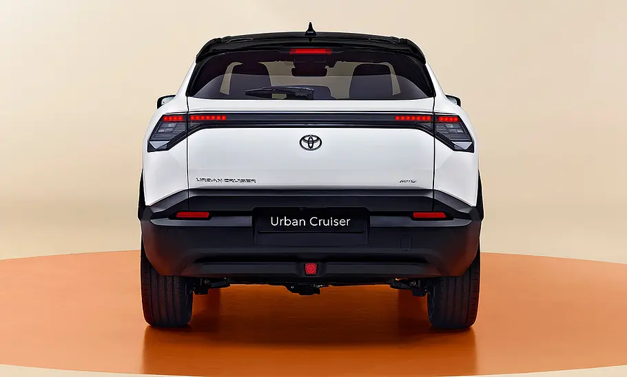 Toyota Urban Cruiser (2025) Toyota Urban Cruiser (2025) im Studio vor beigem Hintergrund, Ansicht von hinten.