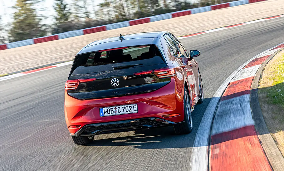 Der VW ID.3 GTX fährt auf der Grand-Prix-Strecke des Nürburgring durch eine Rechtskurve, von hinten fotografiert.