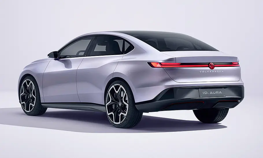 Der VW ID. Aura (2025) steht in Studioumgebung, von hinten rechts fotografiert.