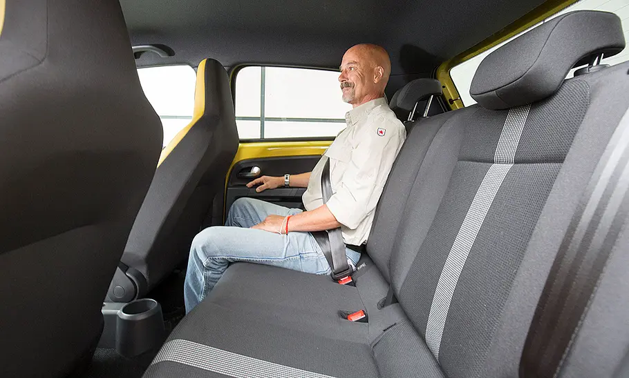 Ein Mann sitzt im Fond des VW Up (2016).