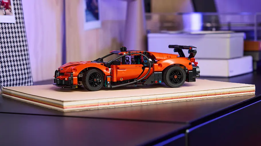Lego Technic Bugatti Chiron Pur Sports Der Chiron Pur Sports von Lego Technic steht auf einem Holzpodest auf einem Schreibtisch.
