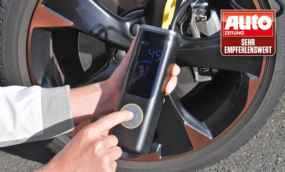 Testerhände mit Fanttik X9 Apex, fotografiert von der Seite. Akku-Luftpumpe Fanttik X9 Apex im Test