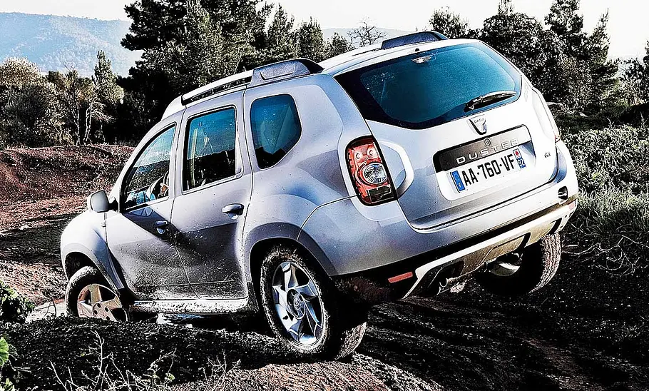 Der Dacia Duster fahrend auf einer schlammigen Piste mit vielen Unebenheiten.