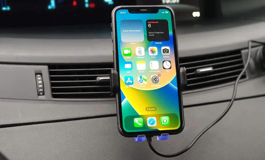 Handyhalterung fürs Auto mit Ladefunktion im Test Der Eoiwuy Fastcharge M20 Wireless Car Charger am Lüftungsgitter eines Armaturenbretts mit Smartphone im Hochformat.